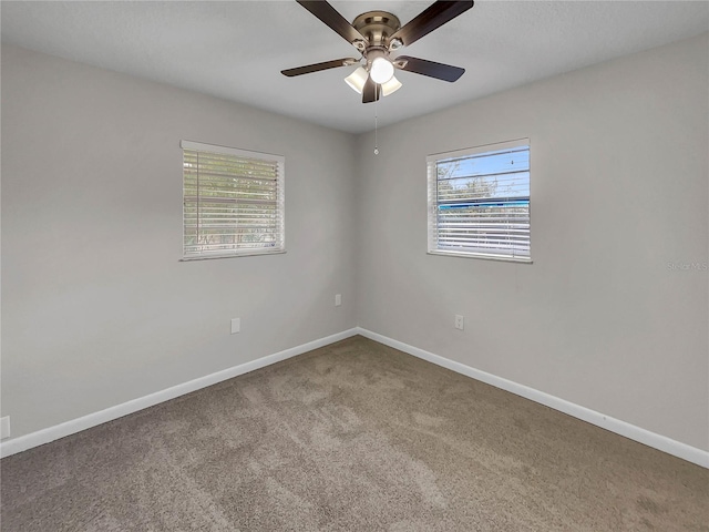 carpeted spare room featuring ceiling fan and a healthy amount of sunlight