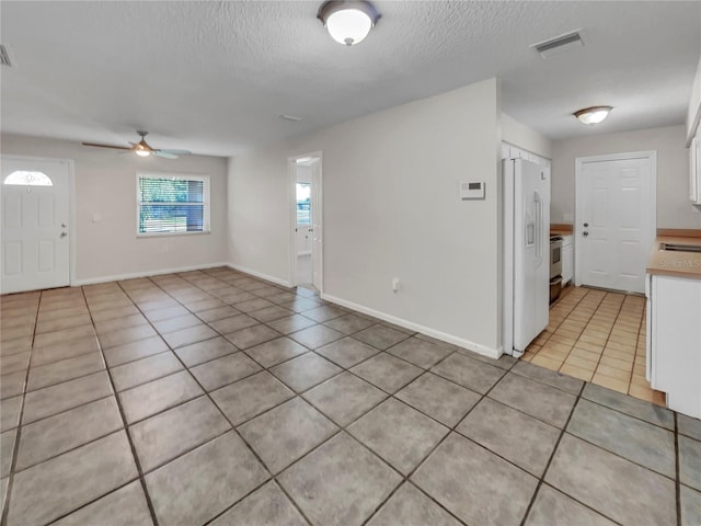 tiled entryway featuring ceiling fan and a textured ceiling