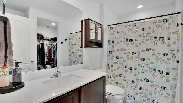 bathroom featuring toilet, vanity, and a shower with shower curtain