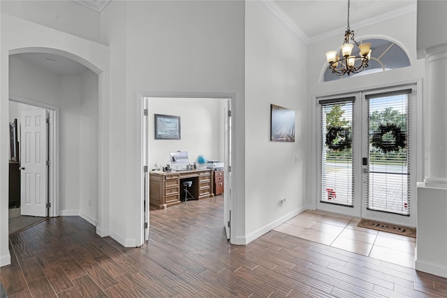 foyer entrance with a chandelier, french doors, and ornamental molding