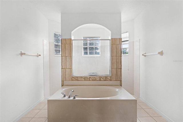 bathroom with tile patterned flooring and a tub