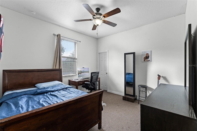 bedroom with ceiling fan, light colored carpet, and a textured ceiling