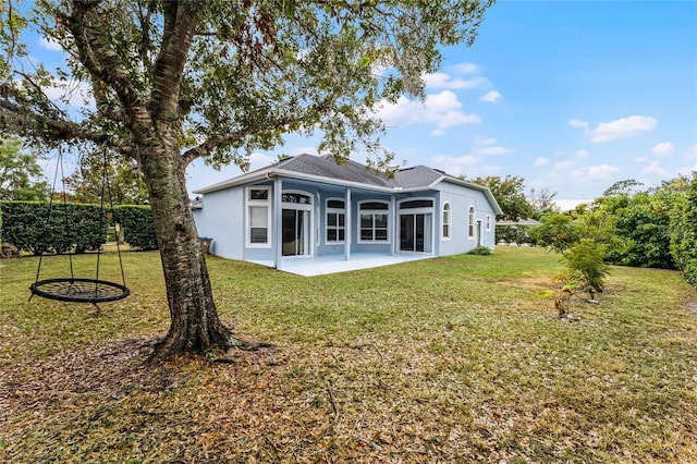 back of property featuring a lawn and a patio