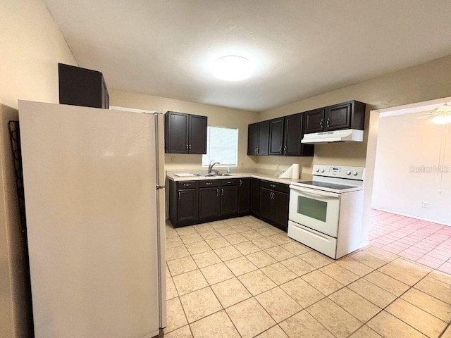 kitchen featuring light tile patterned flooring, white appliances, and sink