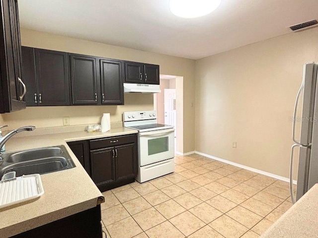 kitchen featuring white range with electric stovetop, stainless steel refrigerator, sink, and light tile patterned flooring