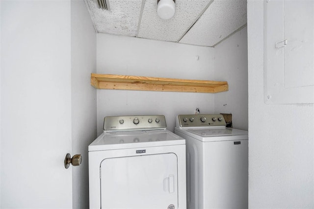 clothes washing area featuring electric panel and washer and dryer