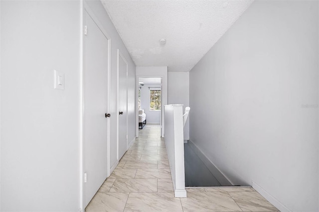 hall with a textured ceiling