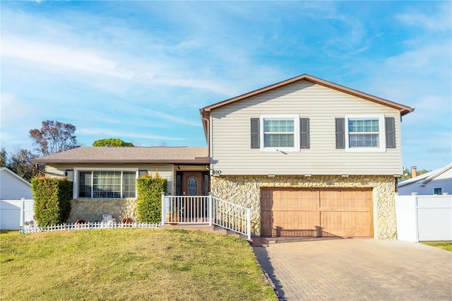 tri-level home featuring a garage and a front lawn