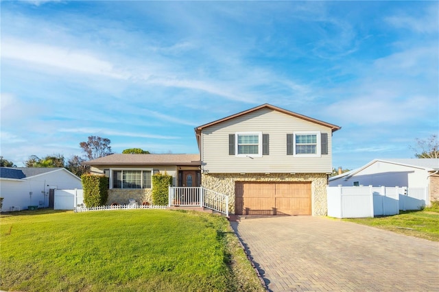 split level home with a garage and a front lawn