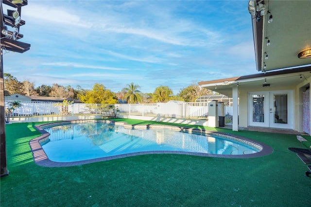 view of pool with a yard and french doors