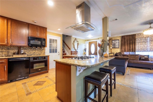 kitchen featuring a kitchen island, a breakfast bar, island range hood, ornamental molding, and black appliances