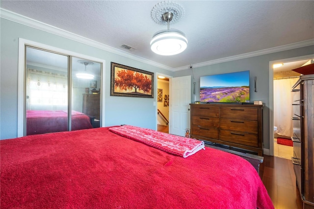 bedroom with crown molding, wood-type flooring, and a textured ceiling