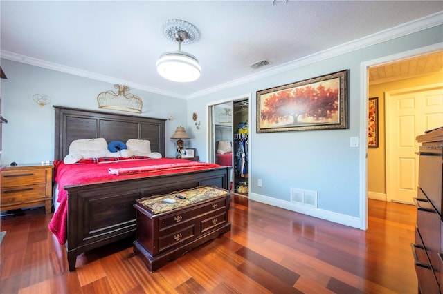 bedroom featuring crown molding, dark hardwood / wood-style flooring, and a closet