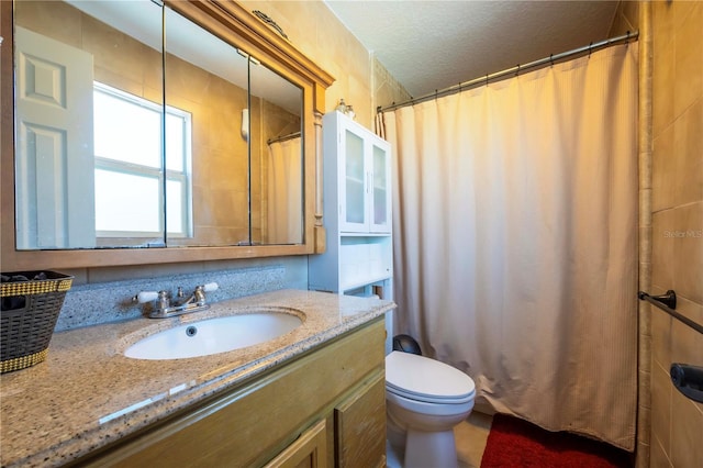 bathroom with a shower with curtain, vanity, toilet, and a textured ceiling