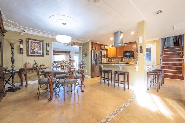 dining space with ornamental molding and light tile patterned floors