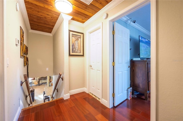 hallway featuring crown molding, dark wood-type flooring, and wooden ceiling