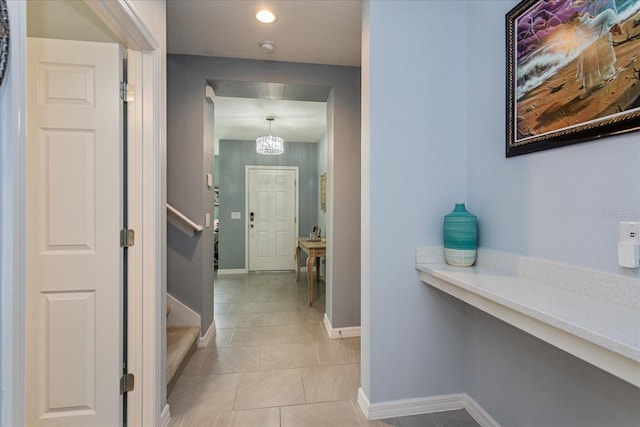 hall featuring a notable chandelier and light tile patterned flooring