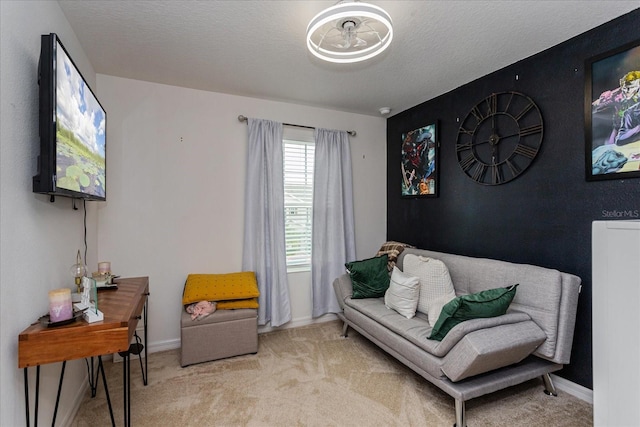 sitting room featuring a textured ceiling and light colored carpet