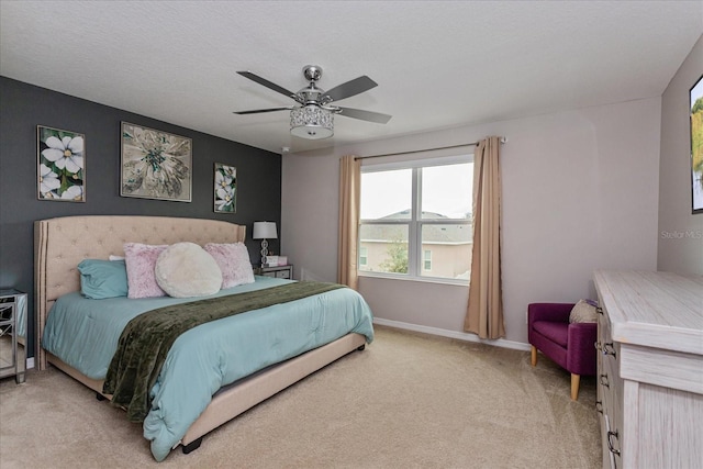 carpeted bedroom with ceiling fan and a textured ceiling