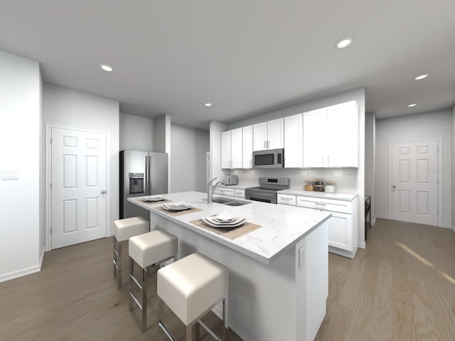 kitchen featuring a kitchen bar, white cabinetry, sink, and appliances with stainless steel finishes