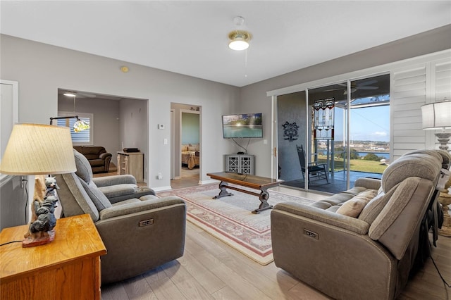 living room featuring ceiling fan, a healthy amount of sunlight, and wood-type flooring