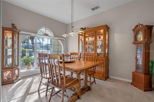 carpeted dining space with a notable chandelier