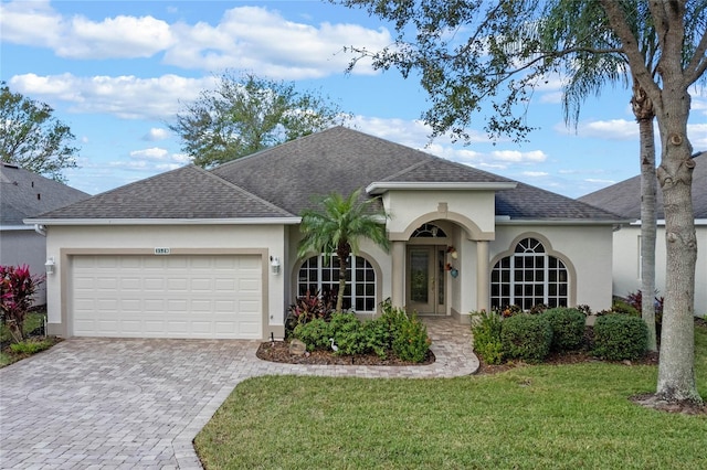 single story home with a garage and a front lawn