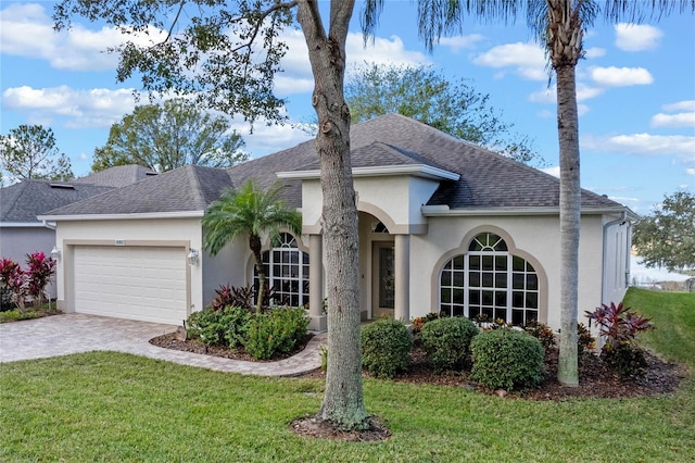 view of front of home with a front yard and a garage