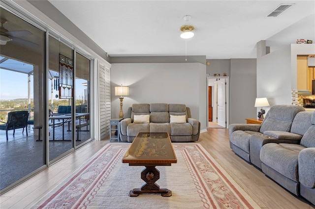 living room featuring ceiling fan and light hardwood / wood-style floors