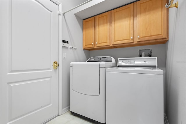 laundry room with washing machine and dryer and cabinets