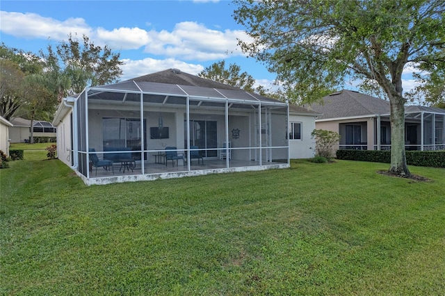 rear view of property with a lanai and a lawn