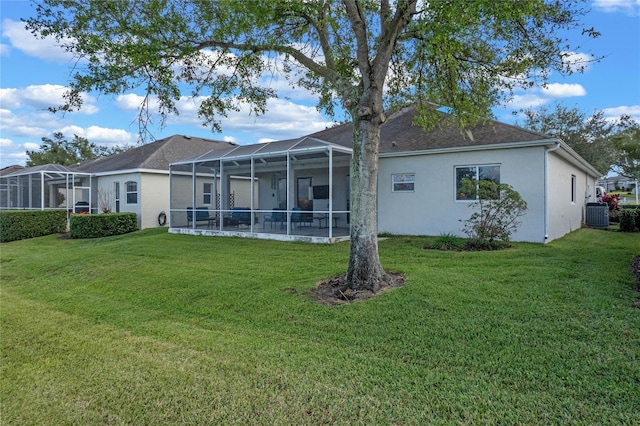 back of house with a lawn, glass enclosure, and central AC unit