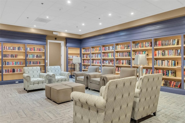 living area featuring built in shelves and light colored carpet