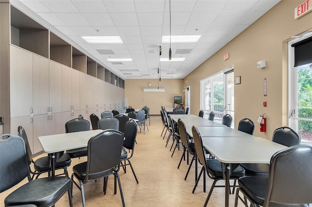 dining room featuring a drop ceiling and light hardwood / wood-style floors