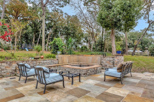 view of patio / terrace featuring a trampoline and an outdoor hot tub