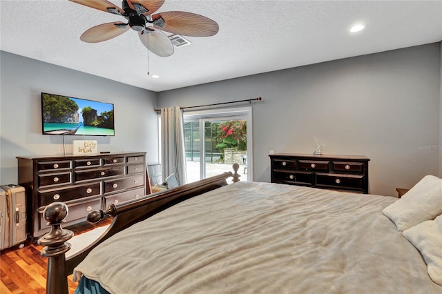 bedroom with a textured ceiling, access to outside, ceiling fan, and hardwood / wood-style flooring