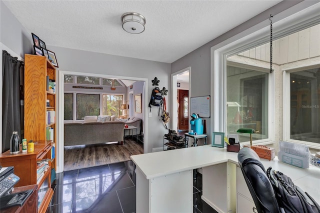 tiled home office with a textured ceiling