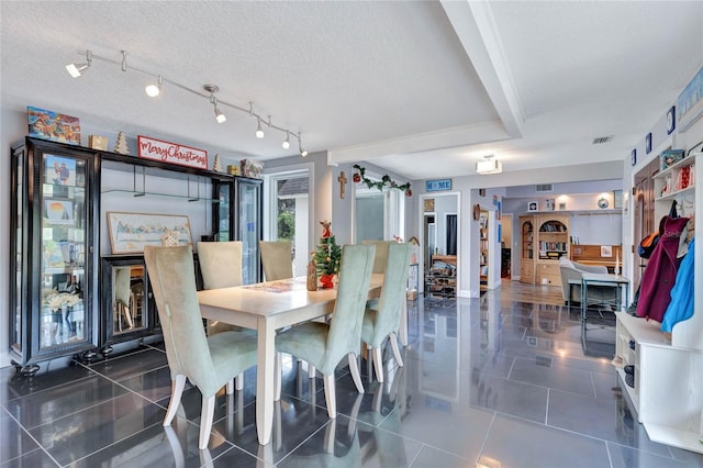 dining space with dark tile patterned flooring and a textured ceiling