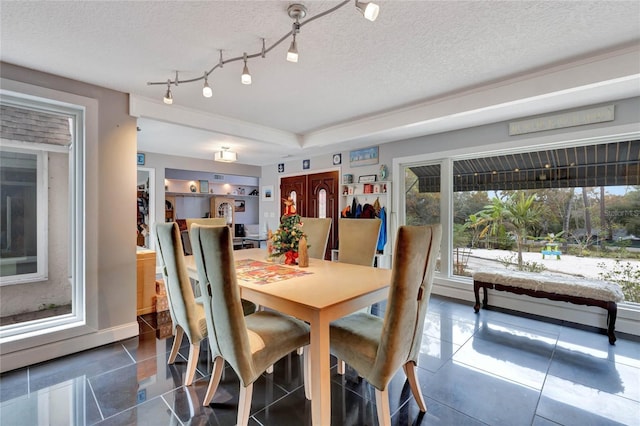 dining space with dark tile patterned flooring and a textured ceiling