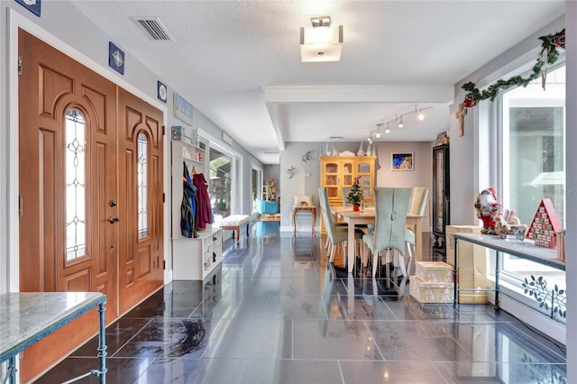 foyer entrance with a textured ceiling