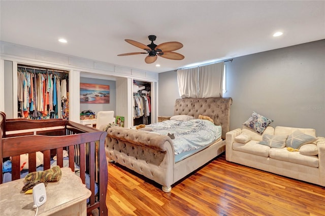 bedroom featuring ceiling fan, a closet, hardwood / wood-style floors, and a spacious closet