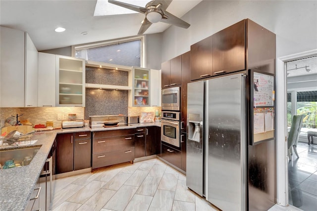 kitchen featuring backsplash, ceiling fan, light stone counters, dark brown cabinetry, and stainless steel appliances