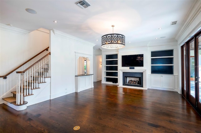 unfurnished living room featuring dark hardwood / wood-style flooring, a notable chandelier, crown molding, and plenty of natural light