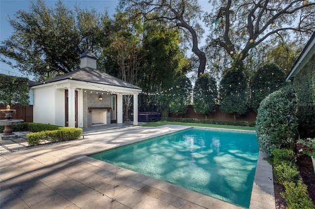 view of pool featuring an outbuilding, a patio area, and a jacuzzi