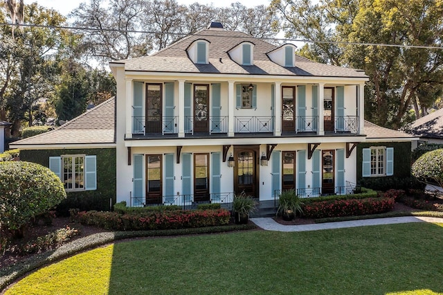 view of front of house featuring a balcony and a front yard