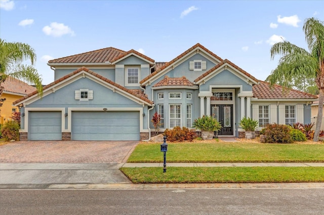 mediterranean / spanish-style house with a garage and a front lawn