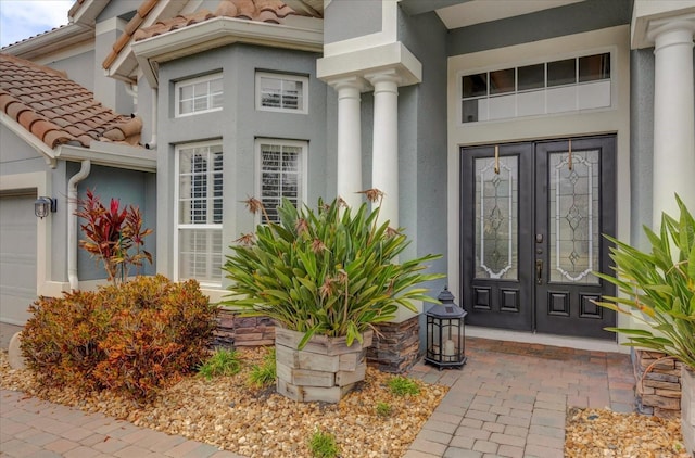 doorway to property featuring a garage and french doors