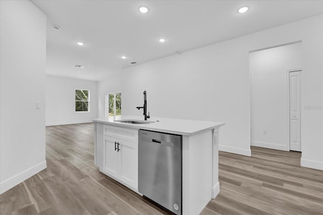 kitchen featuring sink, white cabinetry, light wood-type flooring, an island with sink, and stainless steel dishwasher