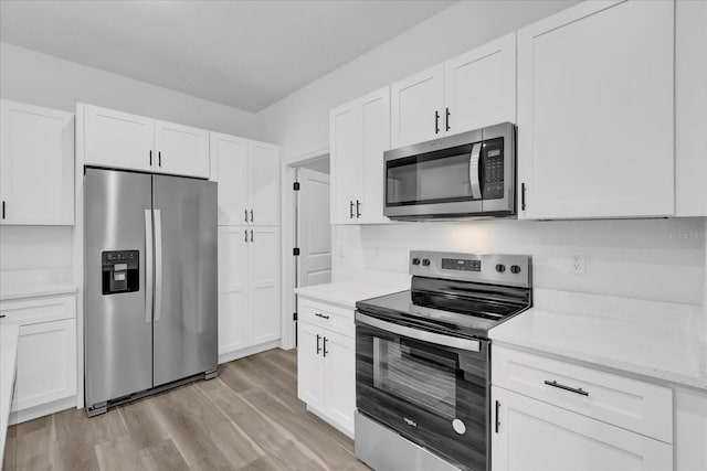 kitchen featuring white cabinets, light hardwood / wood-style floors, light stone counters, and appliances with stainless steel finishes