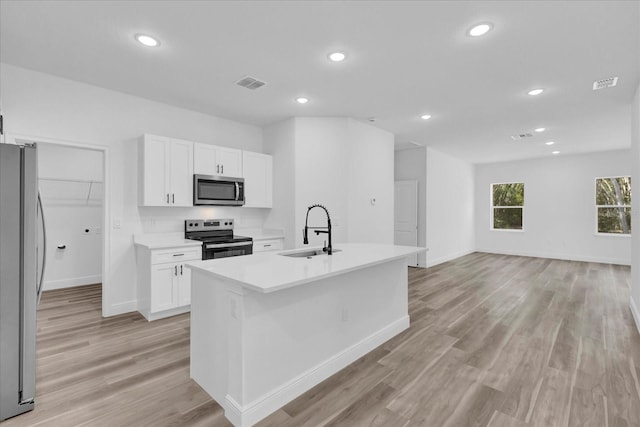 kitchen featuring sink, white cabinetry, an island with sink, and appliances with stainless steel finishes